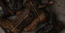 Pair of brown leather boots with intricate designs on a textured surface