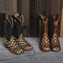 Two exotic boots against a barn door.