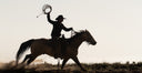 Cowboy holding lasso on horse
